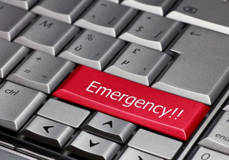 A red emergency button on the keyboard of a computer.